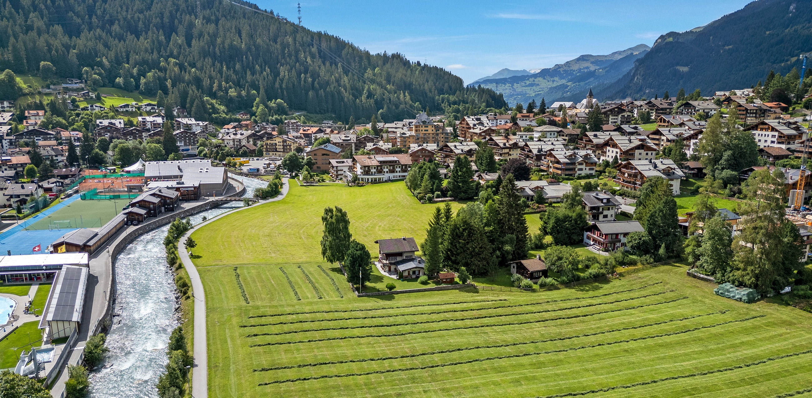 Ferienhaus in den Schweizer Alpen mit Aussicht auf Berge und Wald.