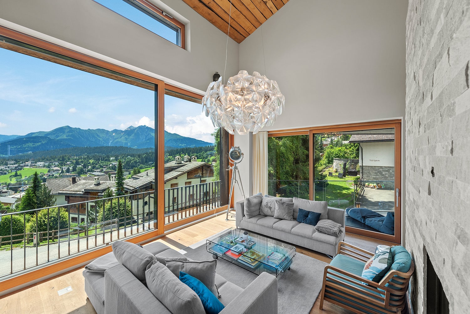 Immobilien verkaufen 3 Panoramablick auf die Alpenlandschaft von Flims mit grünen Wiesen und schneebedeckten Bergen im Hintergrund.