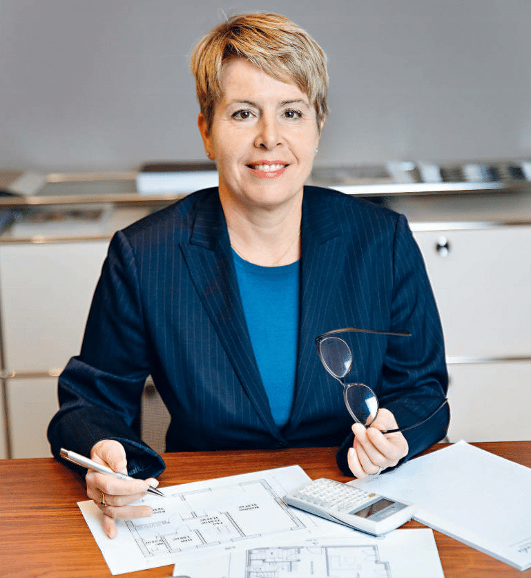 Portrait von Helen Otto, lächelnd vor einem neutralen Hintergrund.