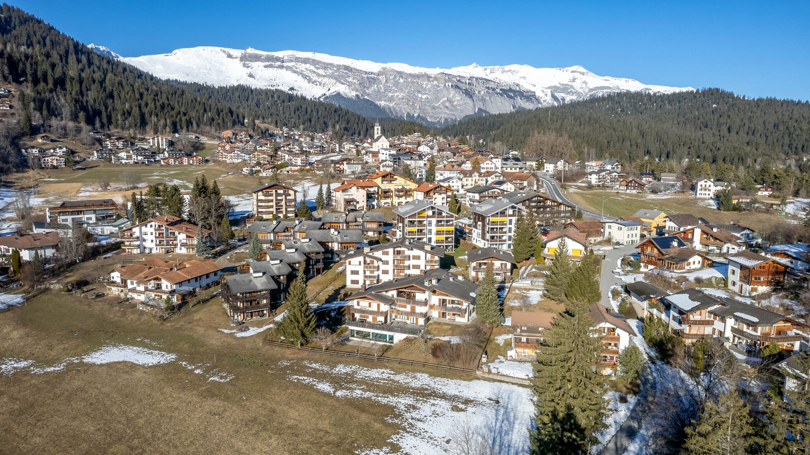 Bergdorf mit Schnee und Sonne
