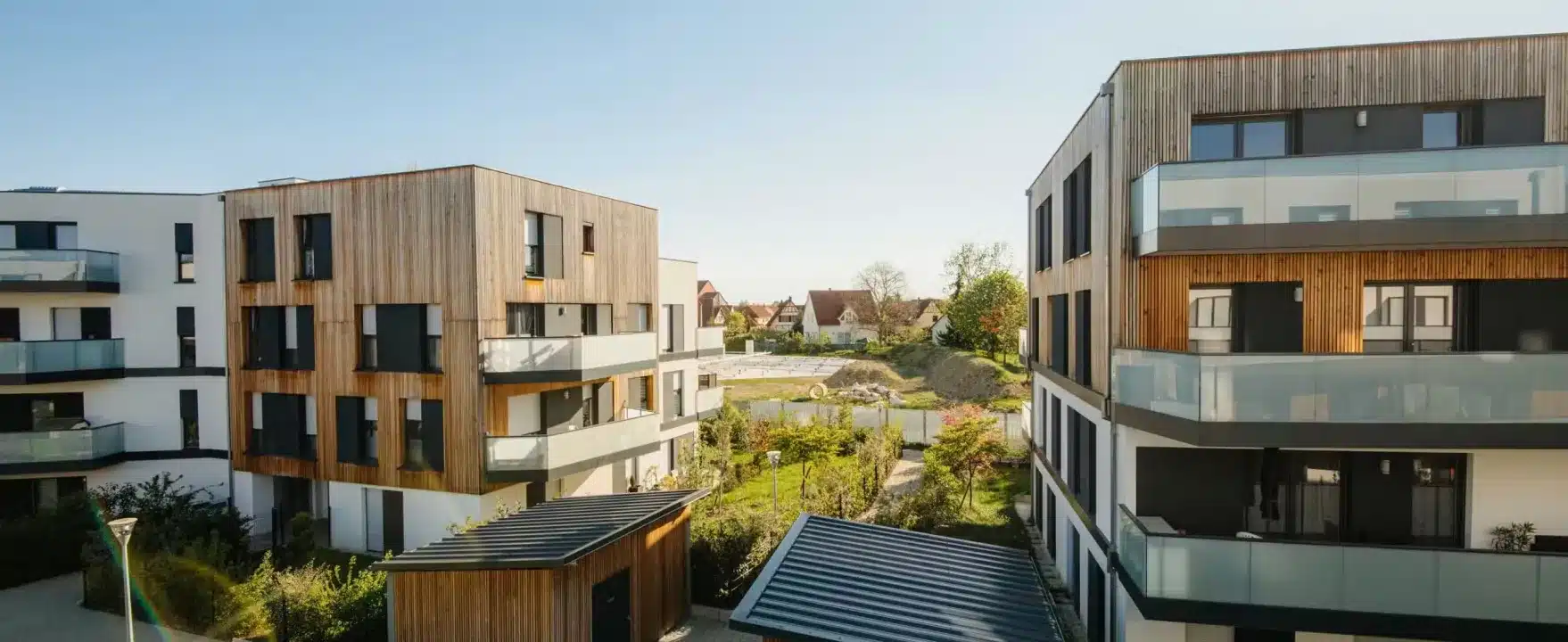 Moderne Architektur eines Mehrfamilienhauses mit begrünten Balkonen in städtischer Umgebung
