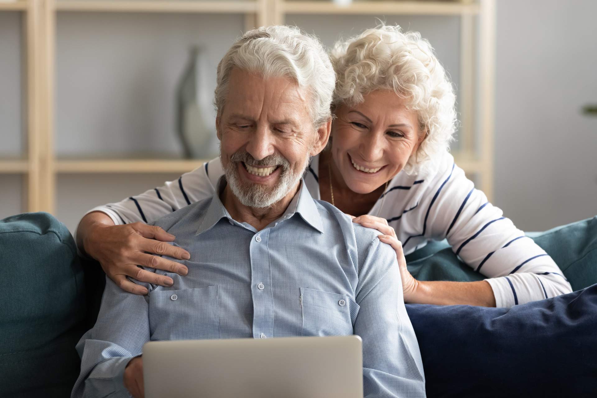 Ehepaar bewertet Immobilienwerte am Tisch mit Dokumenten und Laptop.