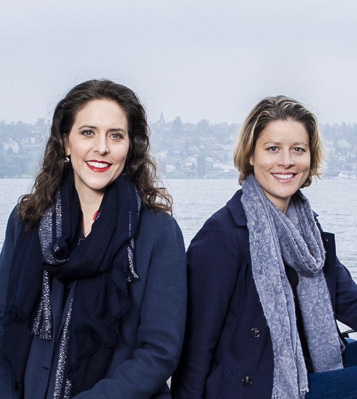 Traumhaftes Landschaftsbild mit blauem Himmel, grünen Wiesen und Bergen im Hintergrund.