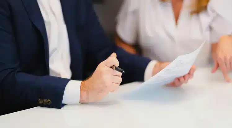 Junge Frau prüft Versicherungsunterlagen in einem modernen Büro für Immobilienberatung.