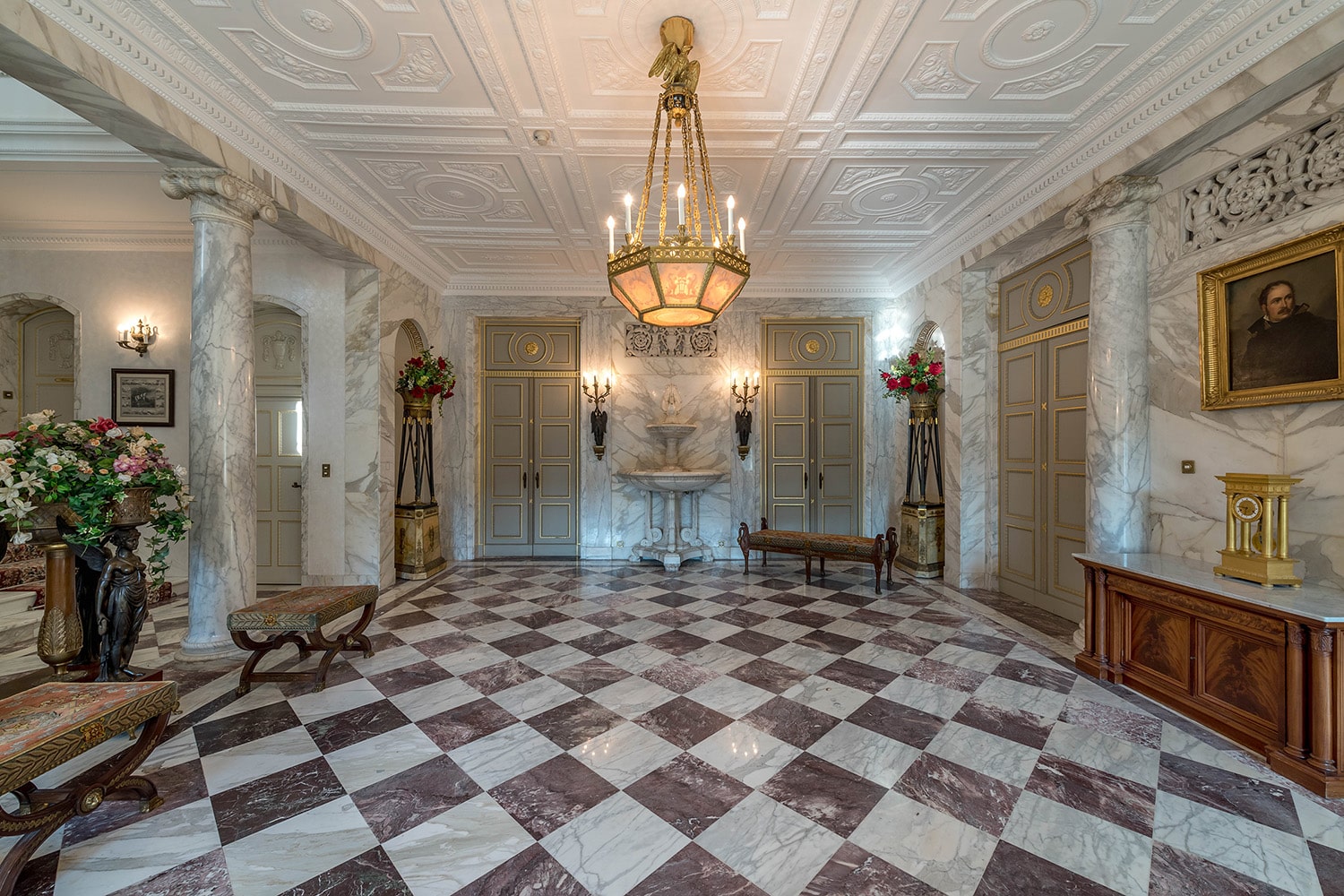 Innenansicht eines eleganten Schlosszimmers mit historischen Möbeln und reich verzierten Wänden.