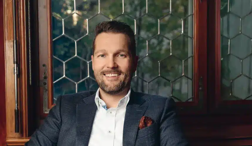 Sascha Ginesta, Geschäftsführer von Ginesta Immobilien, steht vor einem modernen Immobiliengebäude.